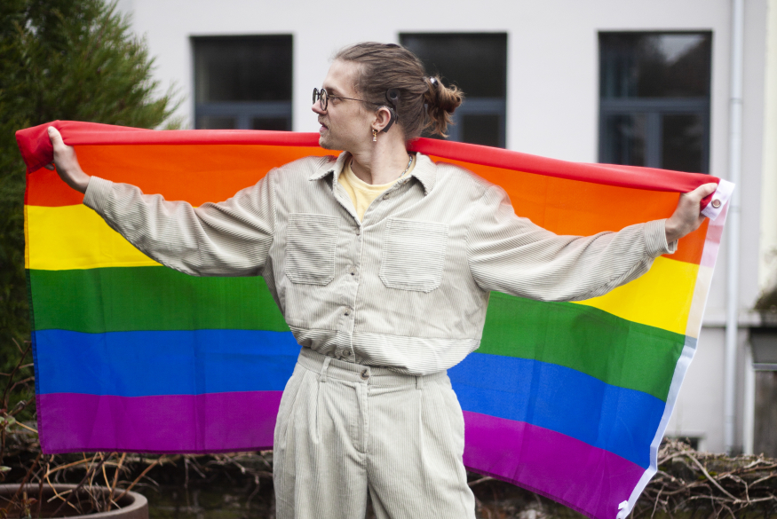 Regenboogvlag Persoon die regenboogvlag achter zich vasthoudt