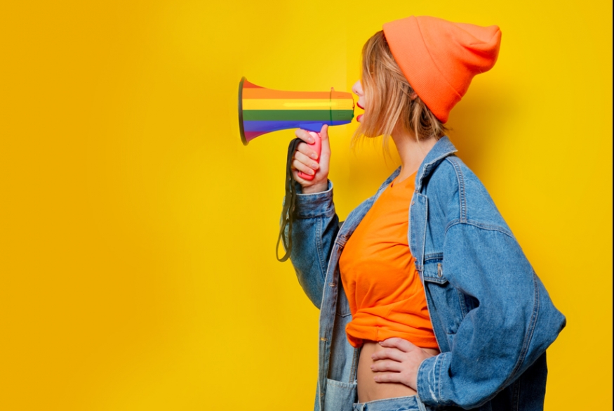 vrouw spreekt door regenboogkleurige megafoon 