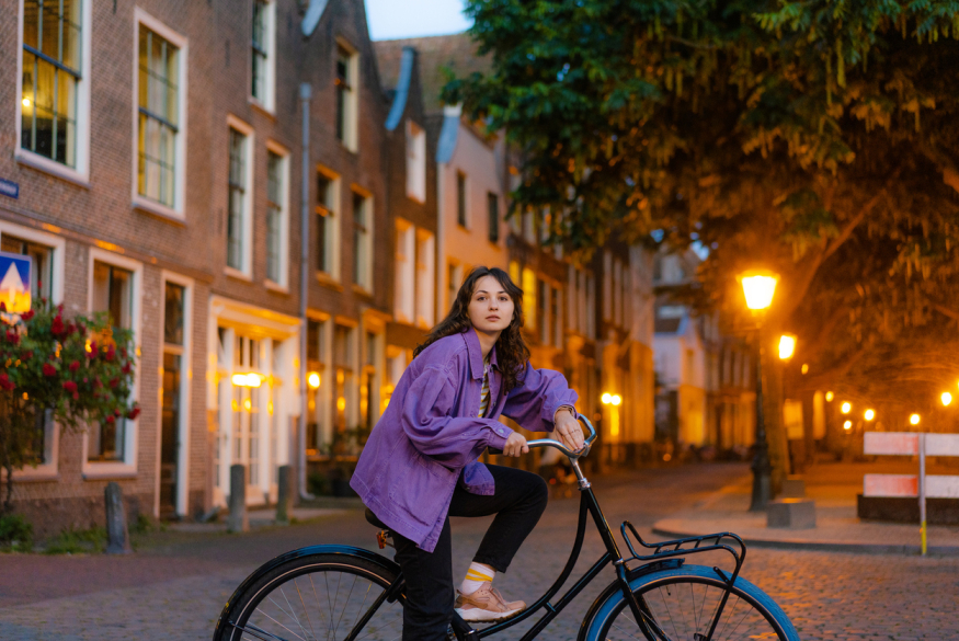 Leerling op de fiets in de stad in de schemering