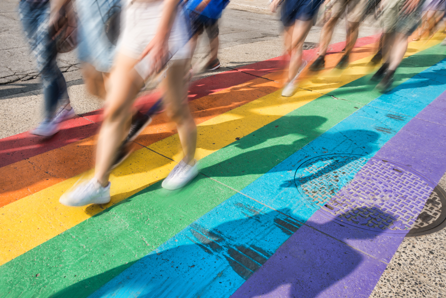 wazige beelden van onderlichamen die wandelen op een regenboogzebrapad