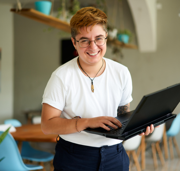 Persoon met witte t-shirt staat recht en heeft laptop vast