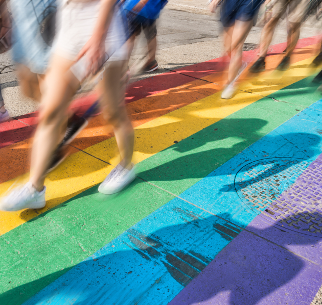 wazige beelden van onderlichamen die wandelen op een regenboogzebrapad