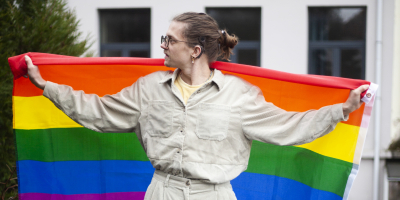 Persoon die regenboogvlag achter zich vasthoudt