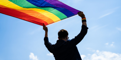 Persoon met regenboogvlag in handen