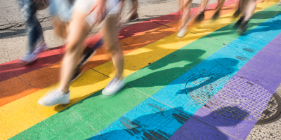 wazige beelden van onderlichamen die wandelen op een regenboogzebrapad