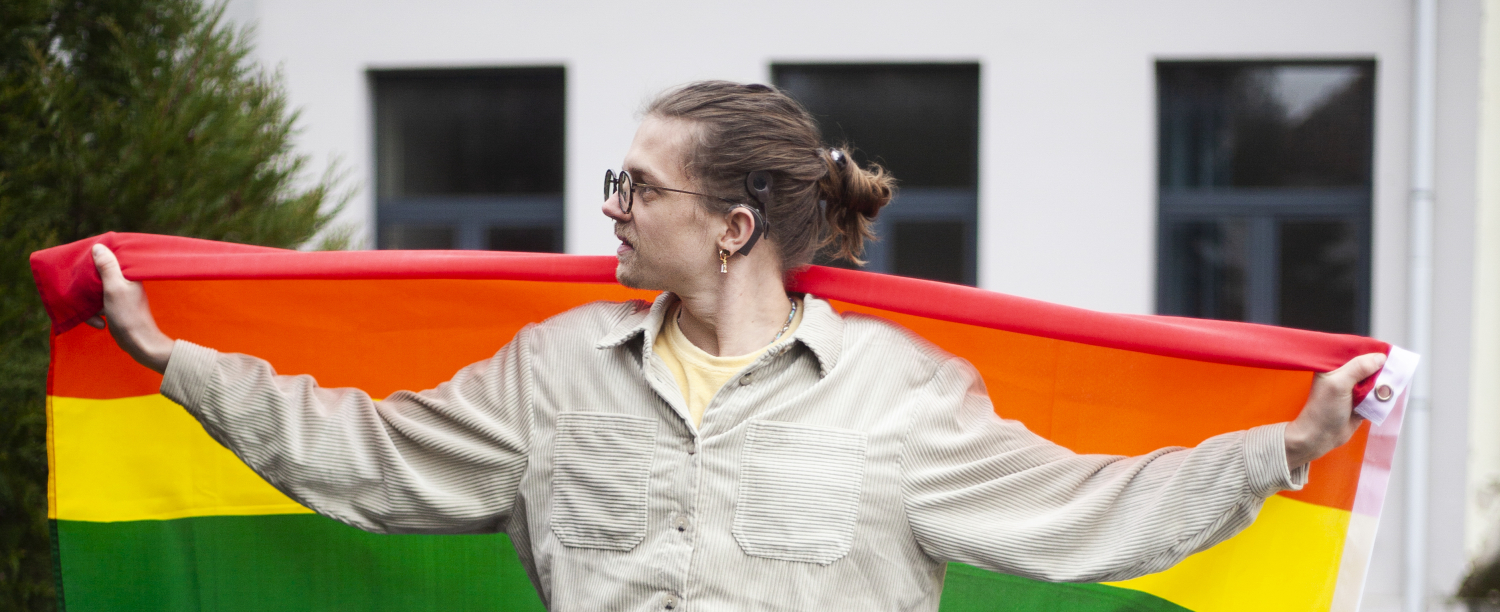 Persoon die regenboogvlag achter zich vasthoudt