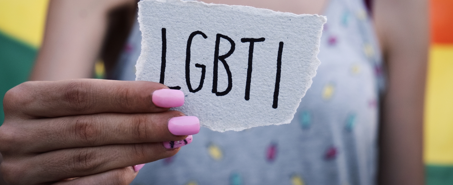 Persoon houdt papier vast met de letters 'LGBTI' op