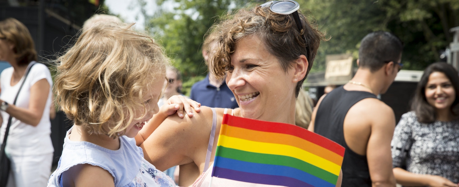 Volwassene met kind en regenboogvlag Volwassene met kind en regenboogvlag