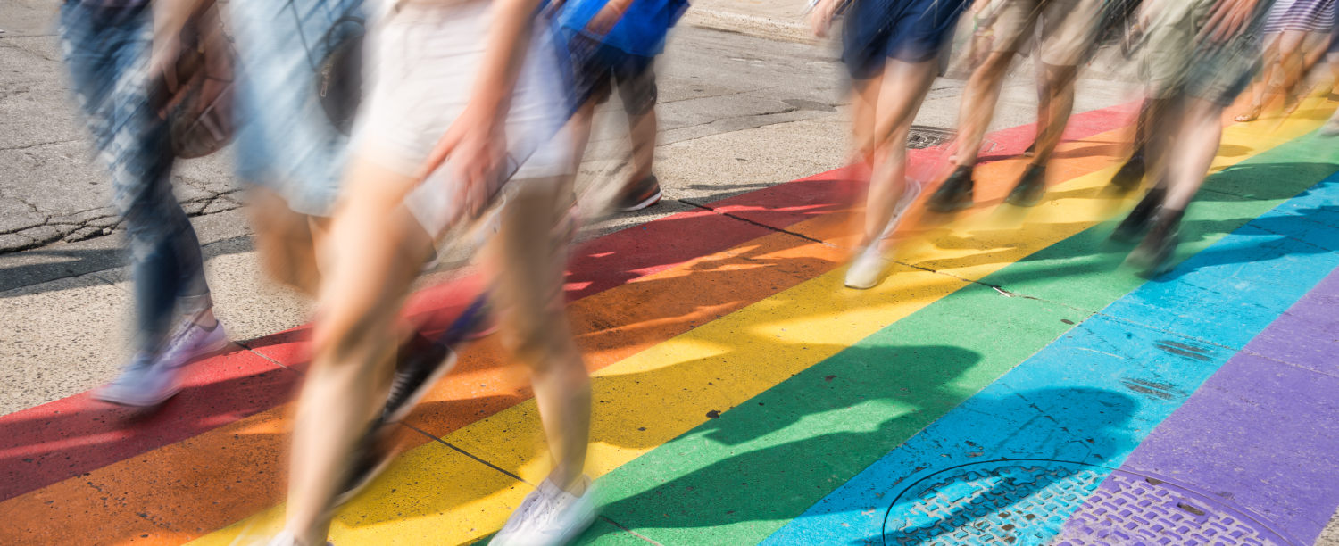 wazige beelden van onderlichamen die wandelen op een regenboogzebrapad